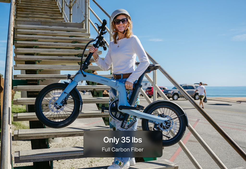 Woman carrying a folding e-bike upstairs
